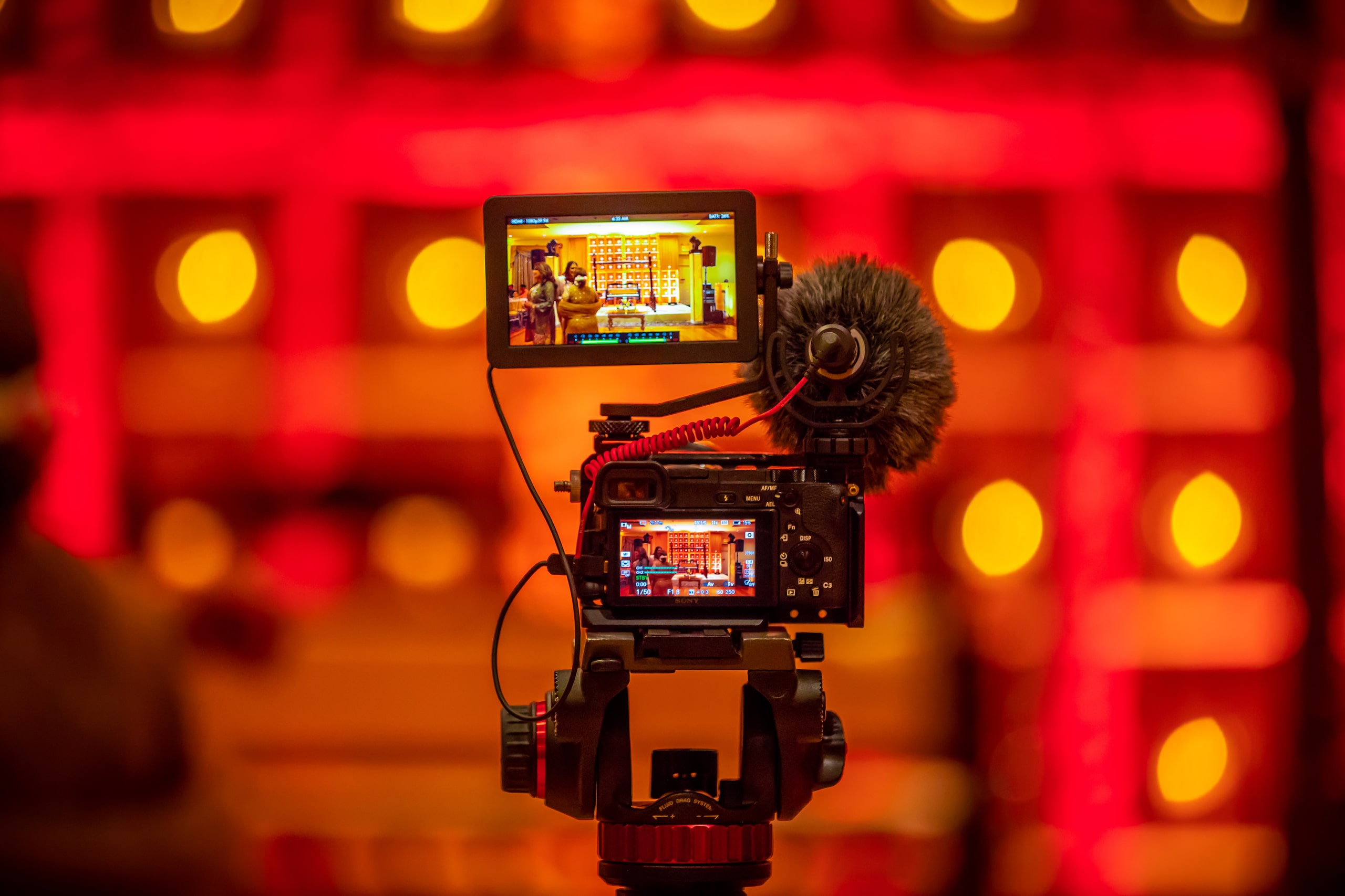 Video camera on a rig against red lights, illustrating transcoding