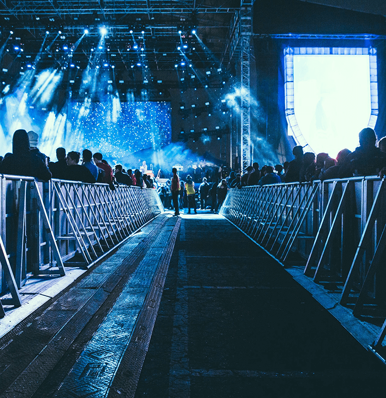 Concert crowd at a stage with blue lights, live event webcasting