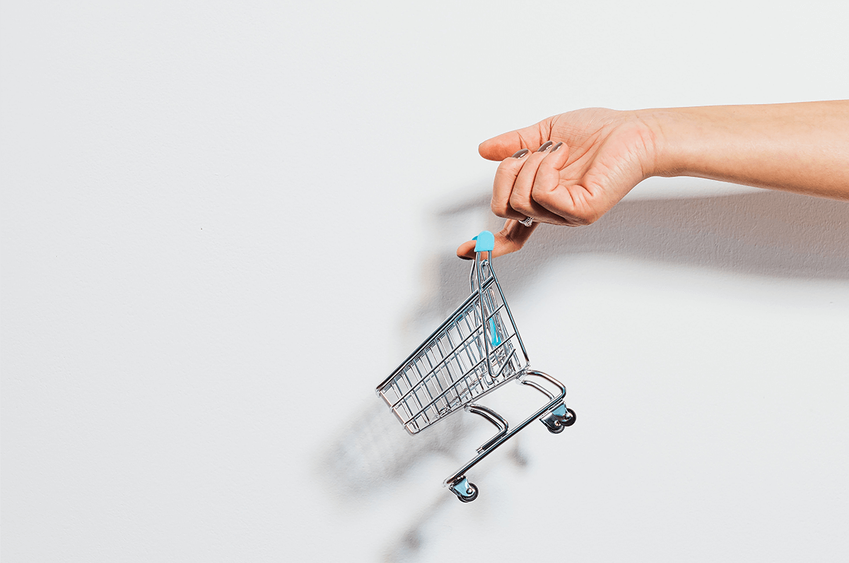 Hand holding a miniature shopping cart, cover for video for commerce