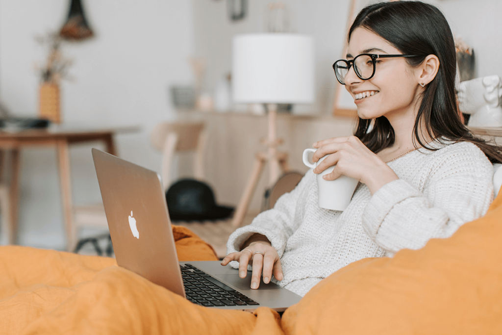 Woman with coffee watching video on a laptop, illustrating a recommendation engine