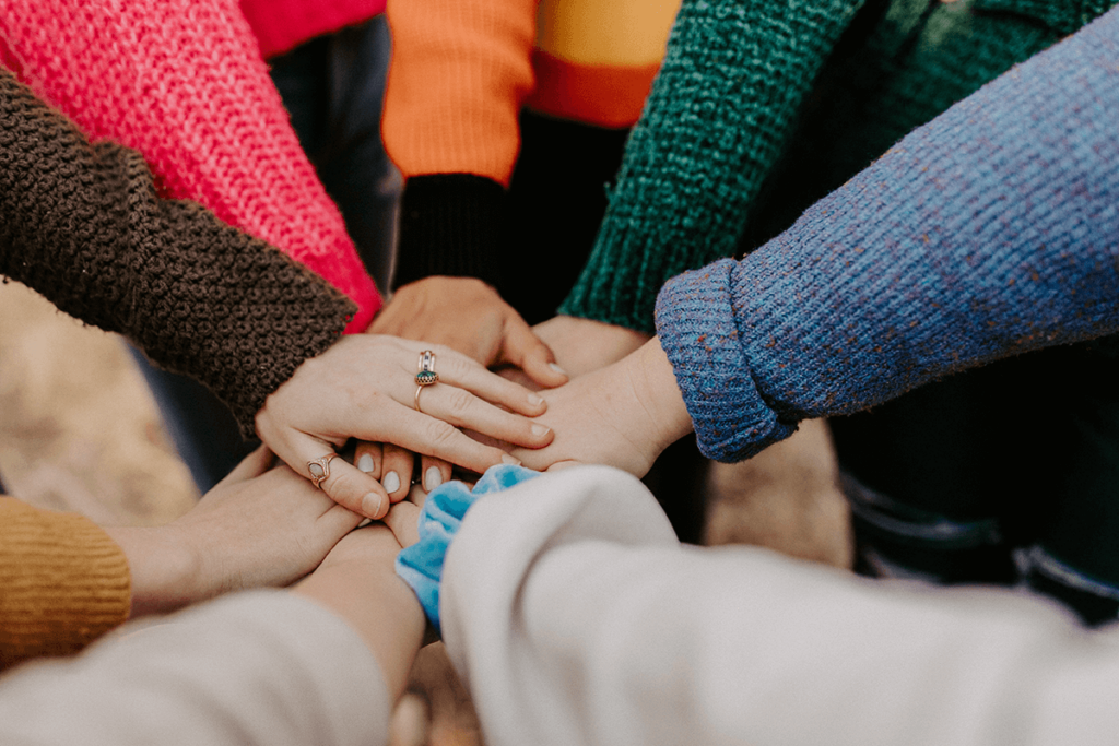 Group of hands stacked together, illustrating bringing your community together