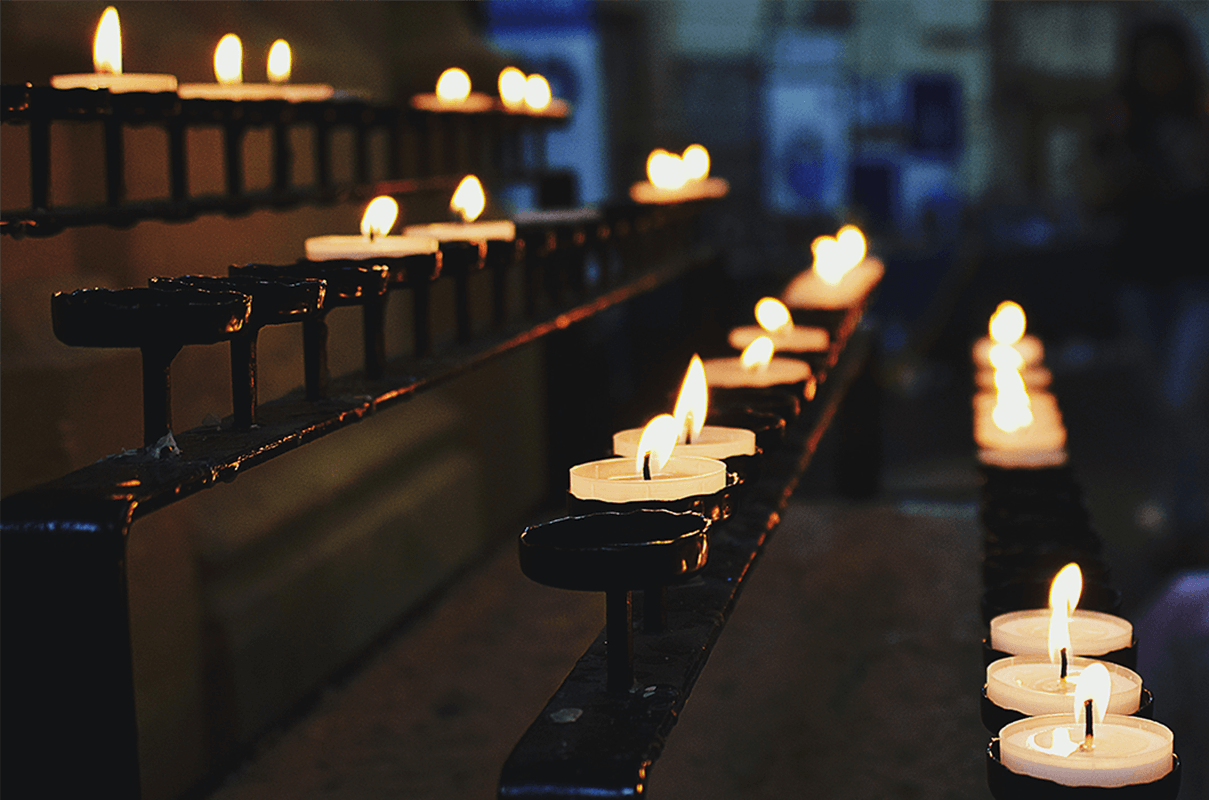 Rows of lit candles in a church, illustrating streaming for faith