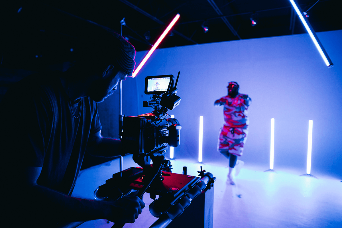 Camera filming a dancer in a neon-lit studio