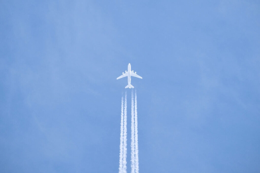 Jet aircraft with contrail in a blue sky, reaching new heights