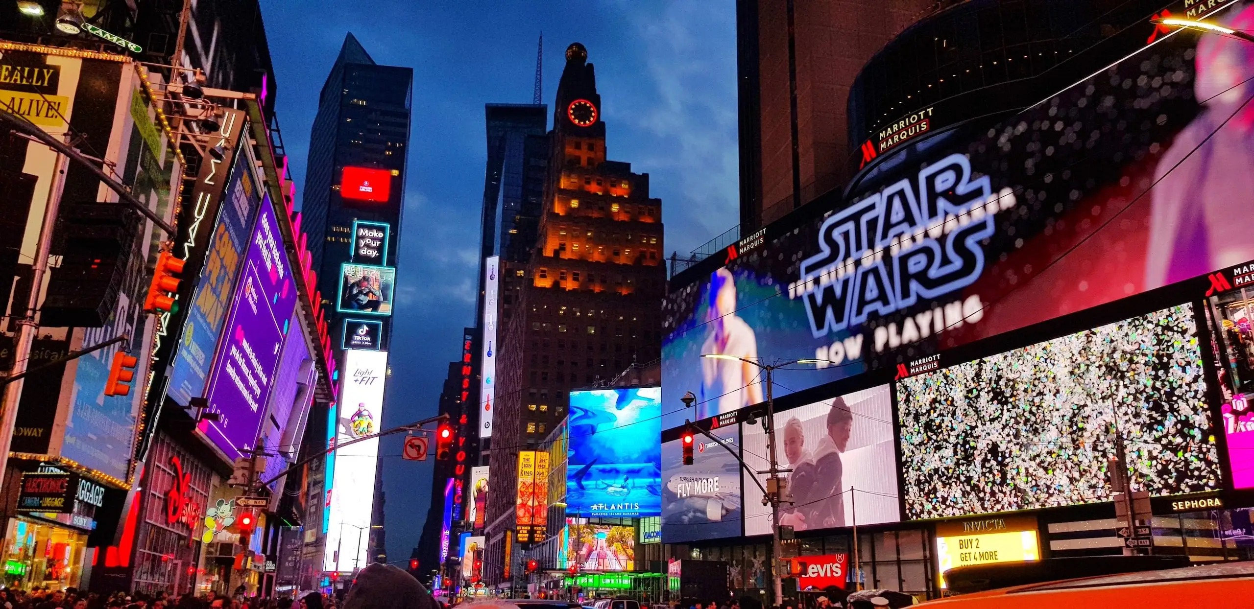 Times Square billboards at night, illustrating that the art comes first
