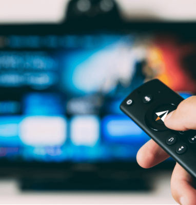 Hand pointing a remote at a TV, AudiencePlayer OTT streaming